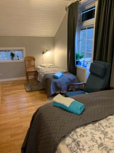 1 dormitorio con 2 camas, silla y ventana en Sea Side Cabin en Borlänge