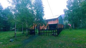 a house with a fence in front of a yard at Selskaya Usadba in Uznezya