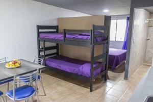 a room with two bunk beds with purple sheets at Rincón Azul in San Rafael