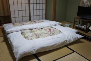 a bed with two pillows on it in a room at Sumiyoshiya in Kanazawa