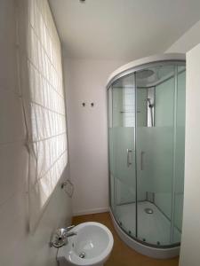 a bathroom with a glass shower and a sink at WHITE LOTUS Apartment in Taormina +25 photos