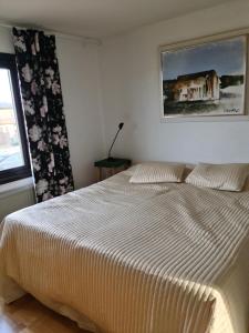 1 dormitorio con 1 cama grande con una foto en la pared en Östra Karup Båstad, en Östra Karup
