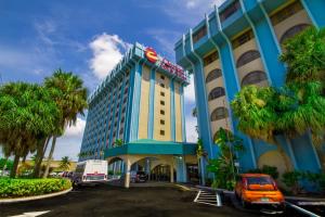 a hotel with a blue building and palm trees at Clarion Inn & Suites Miami International Airport in Miami