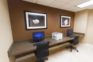 an office cubicle with two computers on a desk at Clarion Inn & Suites Miami International Airport in Miami