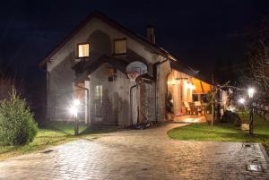 una casa con un aro de baloncesto delante de ella por la noche en "Vučedol"- kuća za odmor **** en Vukovar