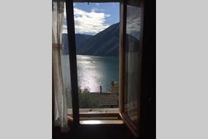ein Fenster mit See- und Bergblick in der Unterkunft Nel set di piccolo mondo antico Villa Viola in Valsolda