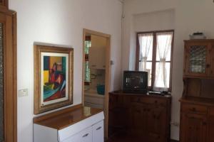 ein Wohnzimmer mit einem TV und einem Spiegel in der Unterkunft Nel set di piccolo mondo antico Villa Viola in Valsolda