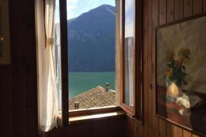 ein offenes Fenster mit Bergblick in der Unterkunft Nel set di piccolo mondo antico Villa Viola in Valsolda