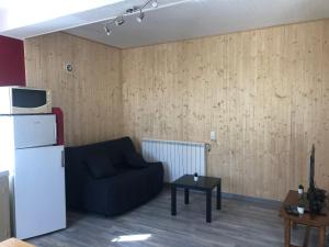 a living room with a couch and a refrigerator at Maison campagne au col du festre in Le Dévoluy