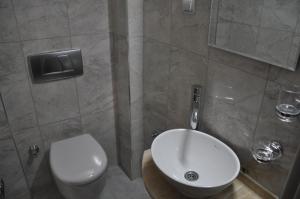 a bathroom with a white toilet and a sink at Sibel Hotel in Antalya