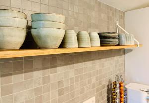 a shelf with bowls on it in a kitchen at So Rosie in Babberich +26 photos