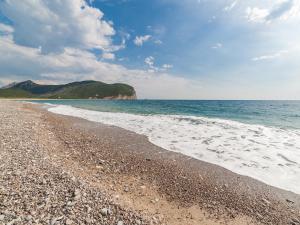 a beach with a rocky shore and the ocean at Luxury Apartments Queen in Petrovac na Moru