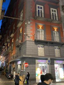 un edificio en una calle con gente caminando delante de él en Salotto Toledo, en Nápoles