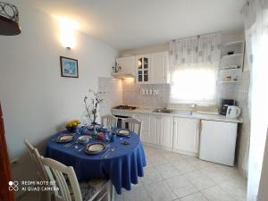 a kitchen with a table with a blue table cloth on it at 21 Kosinac GREEN PARADISE in Vinišće