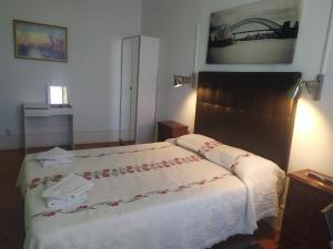 1 dormitorio con 1 cama con colcha blanca en Cenário Catita Hostel, en Lisboa