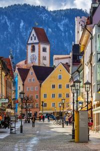 een stadsstraat met gebouwen en een klokkentoren bij Maja in Füssen