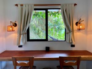 okno w pokoju z 2 krzesłami i drewnianym stołem w obiekcie Mountain Farmhouse Retreat with incredible Views w mieście Minca
