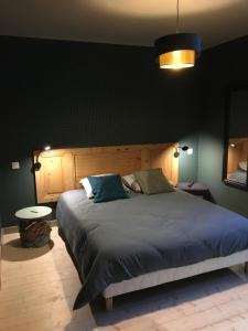 a bedroom with a large bed with a blue comforter at Ess'folie Gîte in Chambles
