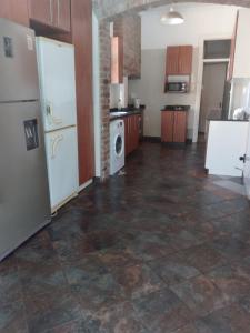 a large kitchen with white appliances and a tile floor at Othandweni Holiday Home in Durban