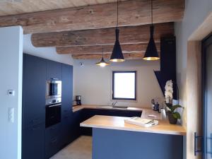 een keuken met blauwe kasten en een bar met verlichting bij Les Burons du Mont-Dore in Le Mont-Dore
