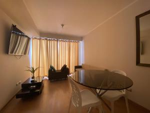 sala de estar con mesa de cristal y sillas en Departamento en Miraflores con Surquillo, en Lima
