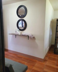 a shelf with two mirrors on a white wall at Hotel Ariana in San Pedro La Laguna