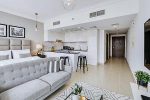 a living room with a couch and a kitchen at GuestReady - Downtown Boulevard in Dubai