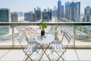 a table and chairs on a balcony with a view of a city at GuestReady - Downtown Boulevard in Dubai