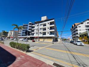 an empty city street with buildings and cars on the road at Apartamento Avenida in Bombinhas