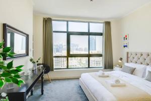 a bedroom with a large white bed and a large window at GuestReady - Serene and Sweet Adieu in Dubai