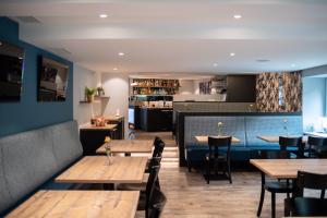 ein Restaurant mit Tischen und Stühlen und einer Bar in der Unterkunft Hotel Gerig in Wassen