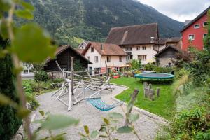 einen Spielplatz in einem Hof mit Häusern und einem Tisch in der Unterkunft Hotel Gerig in Wassen