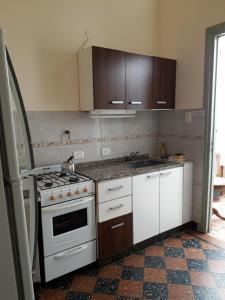 uma cozinha com um fogão e armários brancos em CAsA ARTIGAS 5684 em Buenos Aires