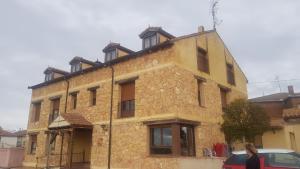 an old stone building with a woman standing in front of it at Puerta al Duraton in Sebúlcor