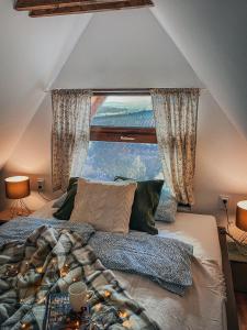 a bedroom with a bed with a large window at Eged Cottage in Eger