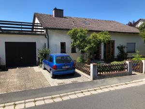 ein blaues Auto, das vor einem Haus geparkt ist in der Unterkunft Ferienwohnung Tom in Schnaittenbach