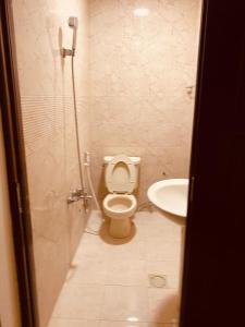 a bathroom with a toilet and a sink at الخزامى in Al Ahsa