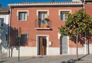un edificio rojo con un árbol delante de él en LA CASA DE LOS PINTORES, junto al centro de Granada, en Granada