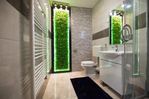 a bathroom with a toilet and a green wall at Apartman Aurelius - private parking in Osijek