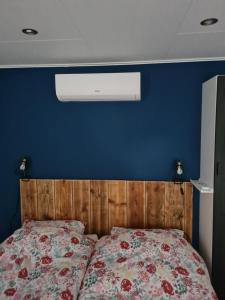 1 dormitorio con 1 cama con pared azul en De Stoof, complete studio voor 2 personen en Renesse