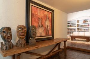 ein Tisch mit drei Holzköpfen darauf und einem Gemälde in der Unterkunft La Provence Restaurant & Hotel Boutique in Cuernavaca