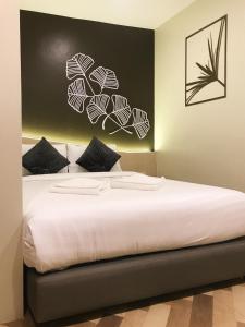 a bedroom with a large bed with white sheets at SJ Miracle Hotel in Hat Yai
