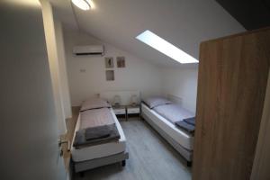 two beds in a small room with a ceiling at Gonsenheim - 3-Zimmer-Haus - max. 5 Personen in Mainz