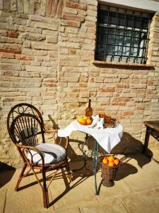 una mesa y una silla con una botella de vino y naranjas. en GaeLeon Campofilone en Campofilone
