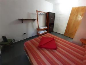 a room with a bed with a red box on it at El Mirador de La Toma in Cosquín