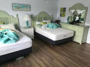 a bedroom with two beds and a mirror at Beautiful Ocean view Townhouse in Cocoa Beach