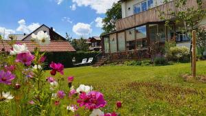 ein Haus mit einem Garten mit Blumen im Hof in der Unterkunft Haus mit stilvoller Ferienwohnung und Tiny House nahe Ammersee für 2-6 Personen in Geltendorf