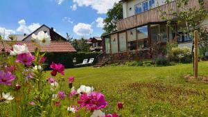 une maison avec un jardin fleuri dans la cour dans l'établissement Haus mit stilvoller Ferienwohnung und Tiny House nahe Ammersee für 2-6 Personen, à Geltendorf