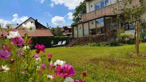 ein Haus mit einem Garten mit Blumen im Hof in der Unterkunft Haus mit stilvoller Ferienwohnung und Tiny House nahe Ammersee für 2-6 Personen in Geltendorf + 12 Fotos