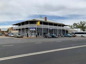 ein Gebäude mit Autos, die vor einer Straße geparkt sind in der Unterkunft Hotel Koorawatha in Koorawatha